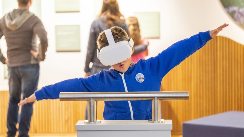 Ein Bub nutzt die VR-Brille im Haus der Wildnis